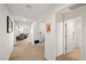 Bright hallway featuring carpeted floors and fresh paint, connecting to a living area and a bathroom at 3924 E Garfield Dr, Pahrump, NV 89061