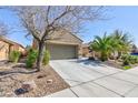 Charming stucco home featuring mature landscaping, a two-car garage, and a paved driveway at 4012 Shetland Pony St, Las Vegas, NV 89122