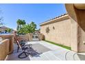 Cozy outdoor patio with seating area, desert landscaping, decorative sunburst and gate access at 4012 Shetland Pony St, Las Vegas, NV 89122