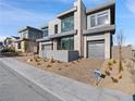 Contemporary two-story home with a two-car garage, modern design, and manicured landscaping at 4880 Argento Peak St, Las Vegas, NV 89135