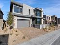 Modern two-story house featuring a gray exterior, well-kept landscaping, and a two-car garage at 4880 Argento Peak St, Las Vegas, NV 89135