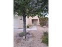Charming single-story home featuring well-maintained landscaping with a mature tree in the front yard at 5830 Springmist St, North Las Vegas, NV 89031