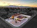 Aerial view of a white single-Gathering house with a red tile roof, solar panels, and xeriscaping at 6220 Carl Ave, Las Vegas, NV 89108