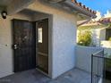 The open front door leads into a cozy condo with a security screen and a view of a sunny interior at 6743 W Charleston Blvd # 4, Las Vegas, NV 89146