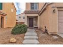 Inviting front entrance with a dark wooden door, desert landscaping and a tile roof at 6949 Copper Bracelet Ave, Las Vegas, NV 89122