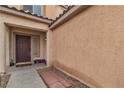 Inviting front entrance with a dark wooden door, desert landscaping and a tile roof at 6949 Copper Bracelet Ave, Las Vegas, NV 89122