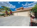 Spacious three-car garage with ample parking space in front, set against a bright blue sky with scattered clouds at 7724 Clearwood Ave, Las Vegas, NV 89123