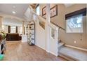Inviting foyer with hardwood floors, a staircase with glass railing, and views into the living area at 8383 Bartholomew Park Ct, Las Vegas, NV 89139
