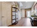 Well-lit entryway featuring hardwood floors, a decorative shelf, and a view of the staircase at 8383 Bartholomew Park Ct, Las Vegas, NV 89139