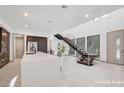 Bright open-concept space with sleek island, modern cabinetry, and staircase with natural light from large windows at 9 Promenade Isle Ln, Henderson, NV 89011
