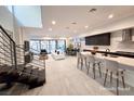 Open-concept living space with modern staircase, kitchen island, and a comfortable seating area at 9 Promenade Isle Ln, Henderson, NV 89011