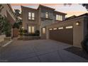 Dusk view of a charming stucco home with a red tile roof and an attached garage at 9044 Opus Dr, Las Vegas, NV 89117