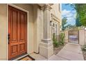 Inviting home exterior with a solid wood front door, a decorative gate, and manicured landscaping at 9044 Opus Dr, Las Vegas, NV 89117
