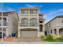 Three-story home showcasing a neutral color scheme, a balcony, and a two-car garage at 9835 Fox Estate St, Las Vegas, NV 89141