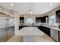 Spacious kitchen featuring stainless steel appliances, dark wood cabinetry, and a large island at 9835 Fox Estate St, Las Vegas, NV 89141