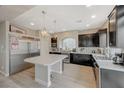 Bright kitchen with a center island, stainless appliances, and dark cabinets at 9835 Fox Estate St, Las Vegas, NV 89141