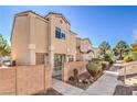 Tan two-story townhouse featuring a gated entrance, and trimmed bushes at , Las Vegas, NV 89118
