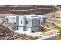 Exterior of a modern two-story home with a three-car garage, landscaped yard, and desert rock border at 1455 Macdonald Ranch Dr, Henderson, NV 89012