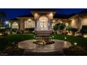 Exterior view of a home with an inviting front entrance with a garden and manicured lawn at 1700 Brock Ct, Las Vegas, NV 89117