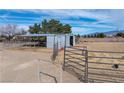 Outdoor barn structure with metal roof and horse fencing in a desert landscape, perfect for equestrian activities at 3581 Ranger Way, Pahrump, NV 89048
