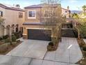 Tan two-story home featuring an attached garage and a long driveway at 3719 Gilmore Creek St, Las Vegas, NV 89129