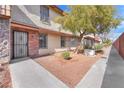 Charming townhome exterior with walkway, complemented by mature trees and desert landscaping at 3946 Torsby Pl # 3946, Las Vegas, NV 89119
