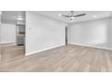 Bright living room featuring wood-look flooring, a modern ceiling fan, and neutral paint at 3946 Torsby Pl # 3946, Las Vegas, NV 89119
