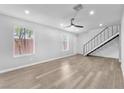 Open-concept living area boasts wood-look floors, a ceiling fan, and staircase access to the upper level at 3946 Torsby Pl # 3946, Las Vegas, NV 89119