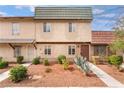 Two-story townhome with colorful roofs, desert landscaping, and inviting walkways, creating a cozy curb appeal at 3986 Visby Ln, Las Vegas, NV 89119