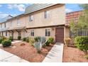 Inviting townhome exterior with lush desert landscaping, creating a warm and inviting atmosphere at 3986 Visby Ln, Las Vegas, NV 89119