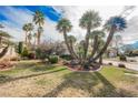 Well-manicured front yard boasting a xeriscaped garden with palm trees, and a lush lawn at 5212 Painted Lakes Way, Las Vegas, NV 89149