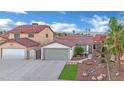 Wide angle shot of single-story home with a tile roof, desert landscaping, and a two-car garage at 585 Jackson Dr, Henderson, NV 89014
