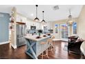 Bright kitchen with a large island, modern appliances, pendant lighting, white cabinets, and bar stool seating at 585 Jackson Dr, Henderson, NV 89014