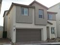 Attractive two-story residence showcasing a neutral stucco exterior and an attached garage with a brick driveway at 6840 Sunflower Fields St, North Las Vegas, NV 89086