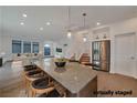 Open kitchen with a large island, pendant lighting, stainless steel appliances, and breakfast bar seating at 8144 Monsoon Bay St, Las Vegas, NV 89113