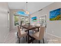 Elegant dining room featuring a chandelier, large windows and a dining table with seating for six at 8904 Saint Pierre Dr, Las Vegas, NV 89134