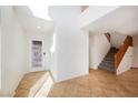 Bright and airy foyer with tiled flooring and staircase leading to the second floor at 9257 Harbor Stream Ave, Las Vegas, NV 89149