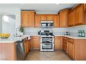 Well-equipped kitchen features stainless steel appliances, wooden cabinets, and quartz countertops at 9257 Harbor Stream Ave, Las Vegas, NV 89149