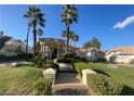 Elegant home featuring stately columns, palm trees, manicured landscaping, and walkway at 12 Innisbrook Ave, Las Vegas, NV 89113