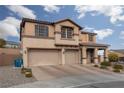 Charming two-story home featuring a three-car garage, landscaped front yard, and inviting front porch at 23 Crescent Palm Ct, Henderson, NV 89002
