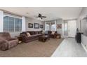 Spacious living room with comfortable seating, a ceiling fan, and an abundance of natural light at 23 Crescent Palm Ct, Henderson, NV 89002