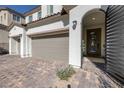 Elegant entry featuring a gated front door, neutral garage doors, and a paved driveway at 3998 Montone Ave, Las Vegas, NV 89141