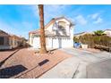 Two-story stucco home with a two-car garage, desert landscaping, mature palm tree, and sidewalk at 4411 Elk Point Cir, Las Vegas, NV 89147