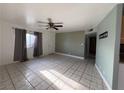 Bright living room with tiled floors, ceiling fan, and large window, perfect for relaxing and entertaining at 5194 Saratoga Dr, Las Vegas, NV 89120