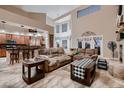 Open-concept living room with a view of the kitchen, featuring tile flooring, comfortable sofas, and high ceilings at 5416 Irish Spring St, Las Vegas, NV 89149