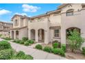 Well-kept townhome featuring stucco exterior, arched entry, and tidy landscaping at 56 Lomita Heights Dr, Las Vegas, NV 89138