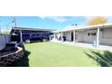 A large backyard with artificial grass featuring a covered parking area at 5617 Tanya Ave, Las Vegas, NV 89107