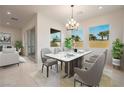 Elegant dining room with a marble table, modern chandelier, and large windows at 6312 Zephyr Peak Ct, Las Vegas, NV 89149