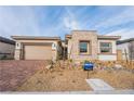 Charming single-story home featuring a brick driveway, stone accents, and a two-car garage at 6312 Zephyr Peak Ct, Las Vegas, NV 89149