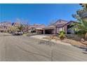 Residential street view of charming single-story home with stone accents, tile roof, desert landscaping and covered parking at 6587 Lucky Boy Dr, Las Vegas, NV 89110